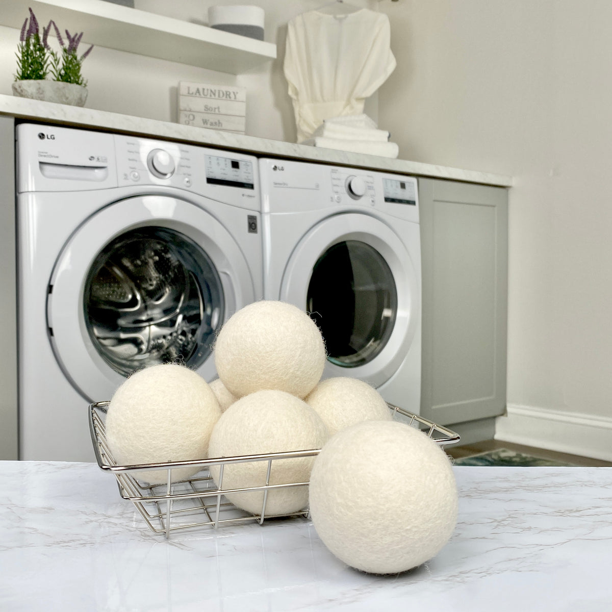 Several Heritage Park Wool Dryer Balls in front of washer and dryer machines