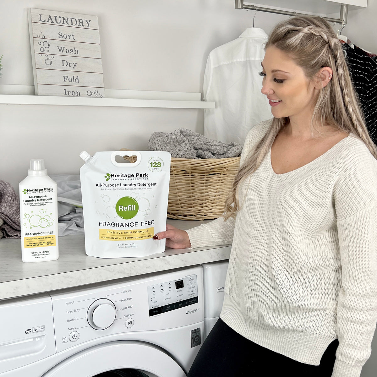 Women with a refill pack of Heritage Park All Purpose Fragrance Free Laundry Detergent and a 32 oz bottle