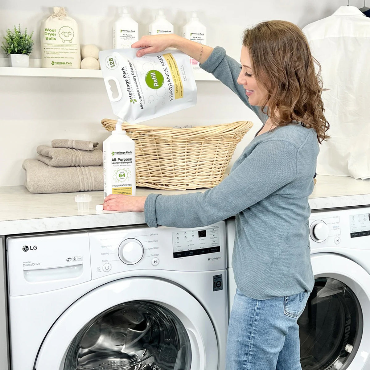 Women pouring Heritage Park All Purpose Fragrance Free Laundry Detergent from a refill pack into a 32 oz bottle