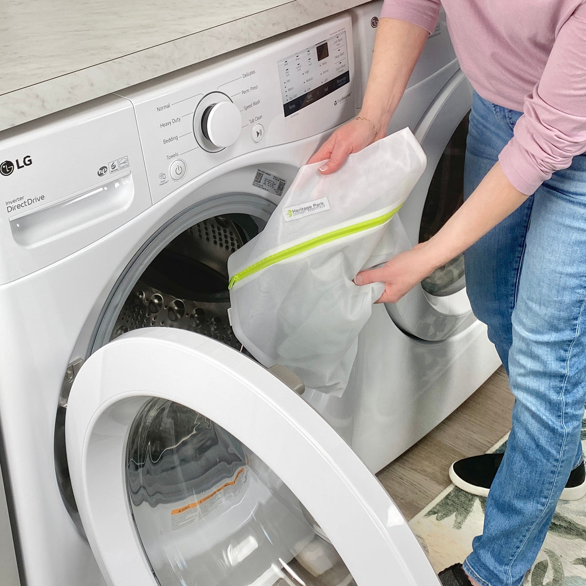 The Heritage Park mesh laundry bag being placed inside the washing machine