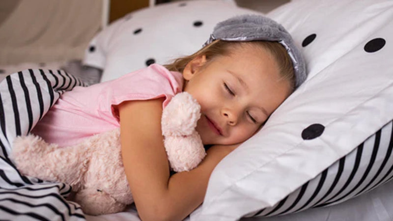 Young girl sleeping with her stuffed animal